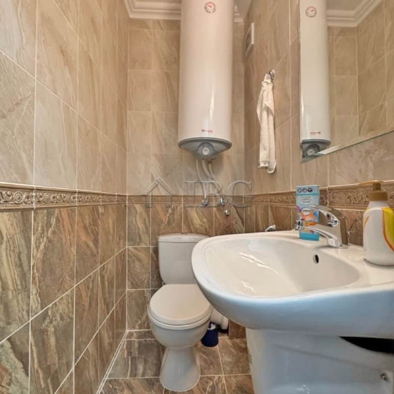 Bathroom with water heater, toilet, and sink in Sveti Vlas apartment.