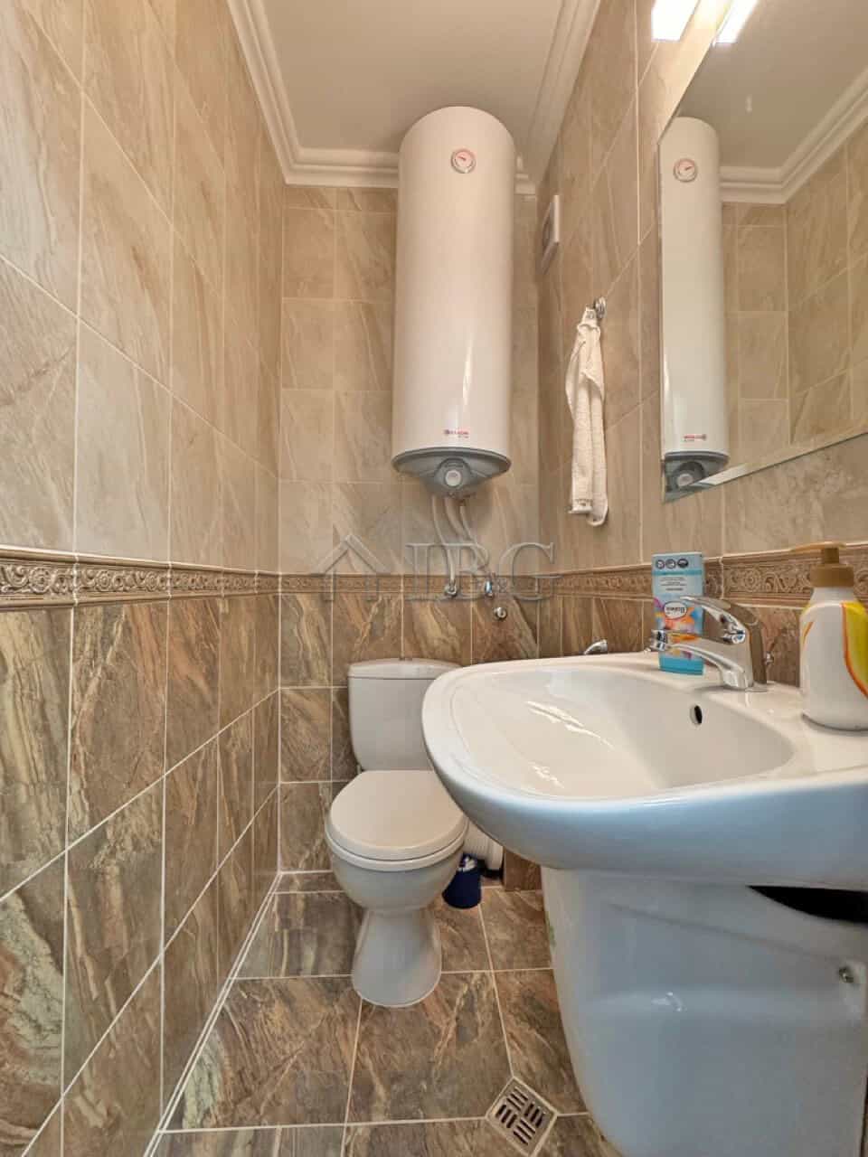 Bathroom with water heater, toilet, and sink in Sveti Vlas apartment.