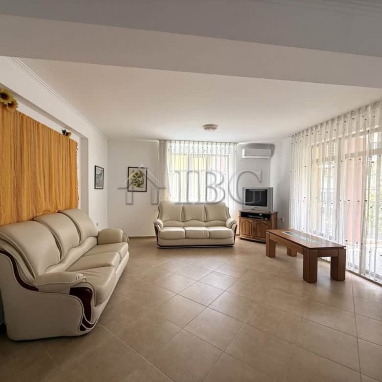 Bright living room with large windows and comfortable sofas in Tili Complex, Aurelia District.