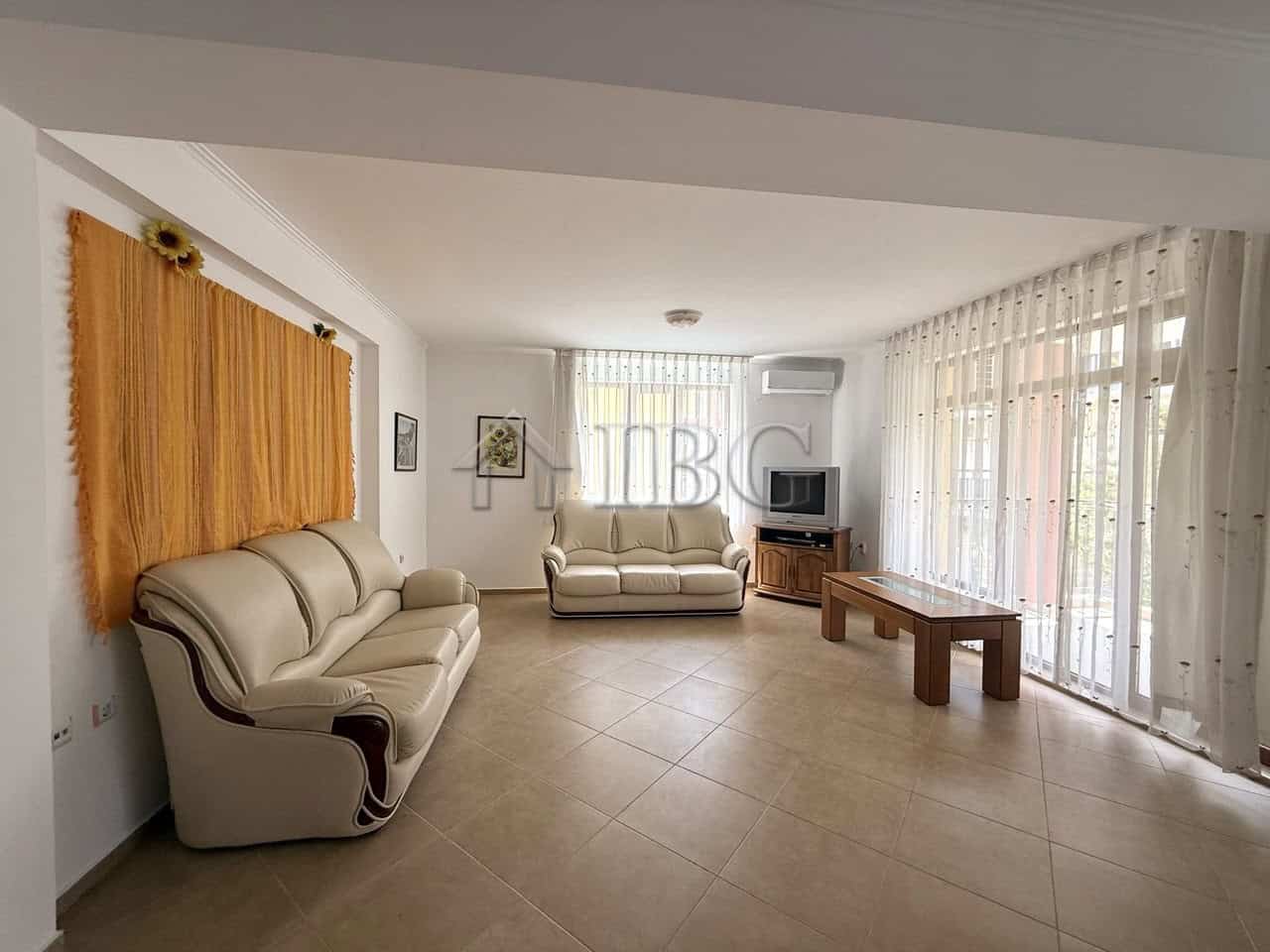 Bright living room with large windows and comfortable sofas in Tili Complex, Aurelia District.