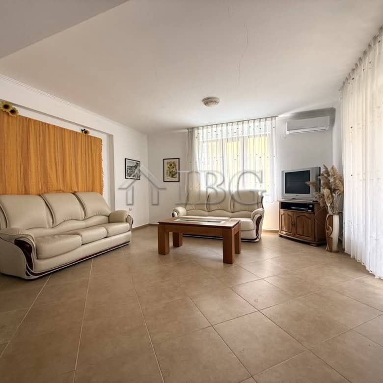 Bright living room with large windows and comfortable seating in Tili Complex, Aurelia District, Nes.