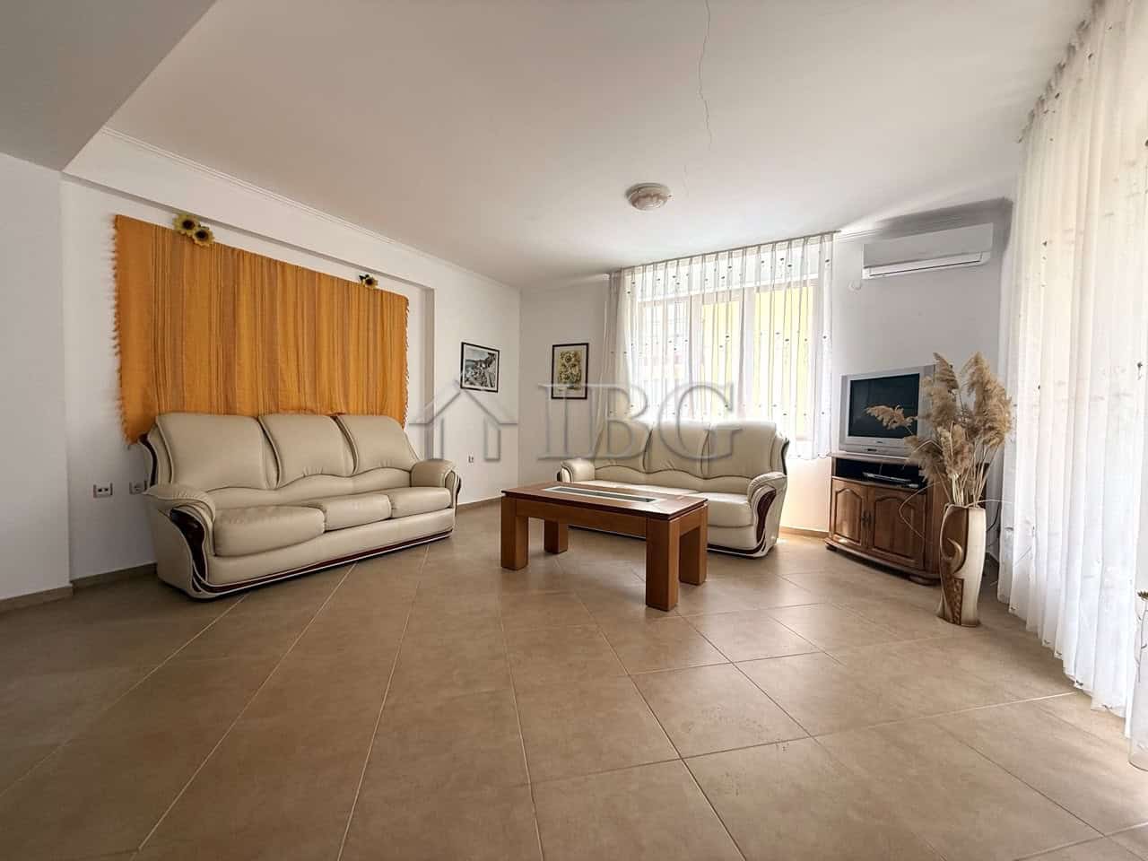 Bright living room with large windows and modern furnishings in Tili Complex, Aurelia District, Ness.