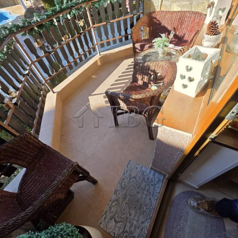 Charming balcony featuring wicker chairs and a small table, perfect for relaxing and enjoying outdoo.