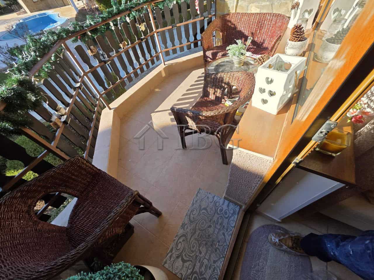 Charming balcony featuring wicker chairs and a small table, perfect for relaxing and enjoying outdoo.