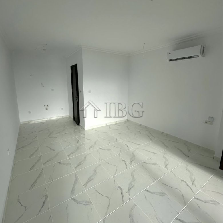 Bright sea view studio with white walls, marble floor, and air conditioning.