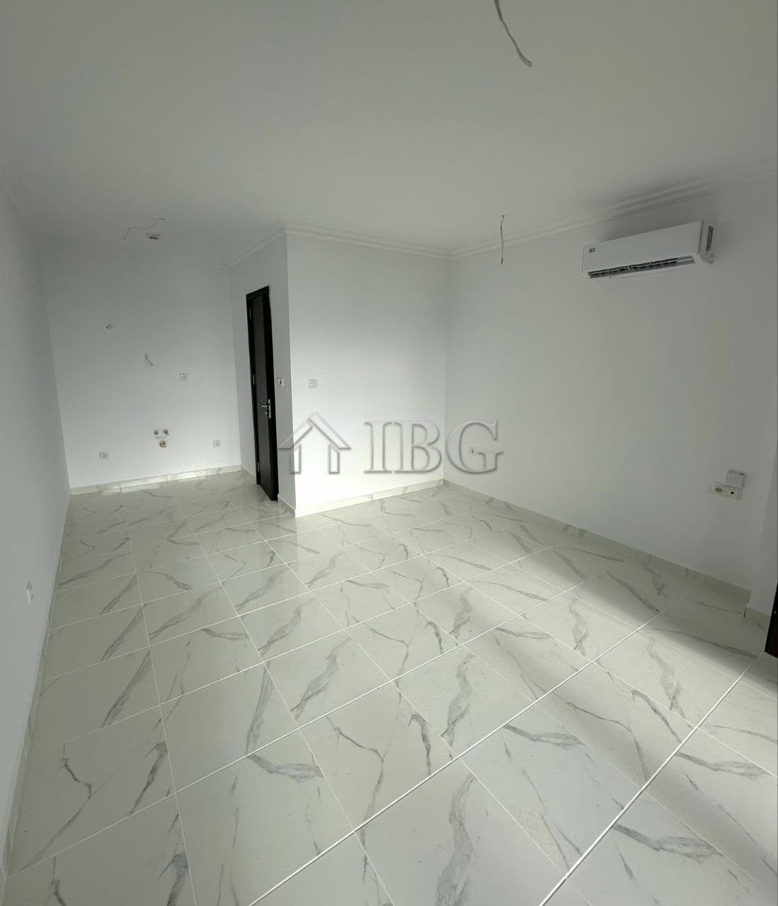 Bright sea view studio with white walls, marble floor, and air conditioning.