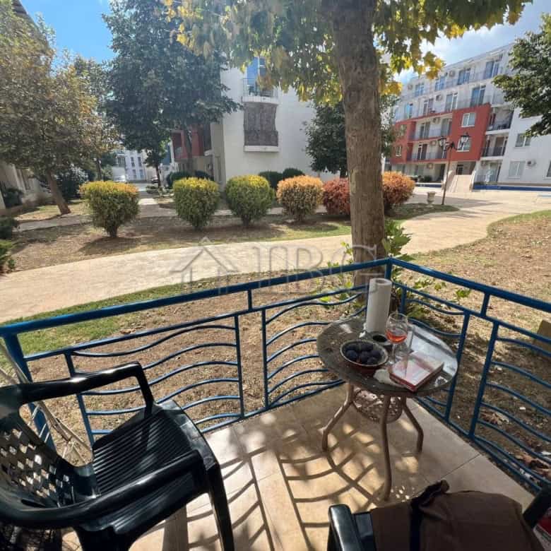 Bright balcony view of Sunny Beach with outdoor seating and lush greenery.