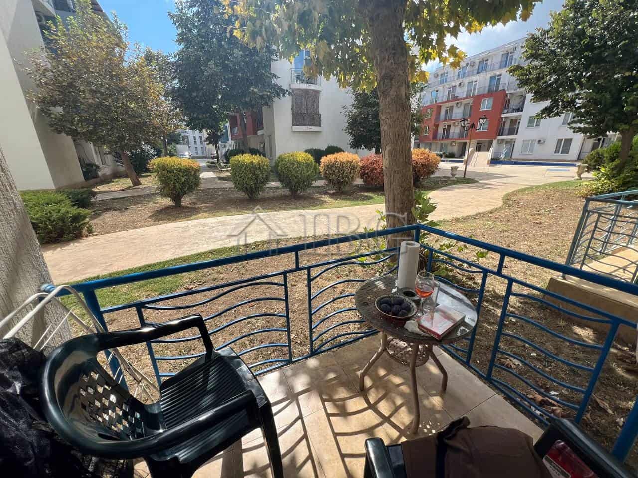 Bright balcony view of Sunny Beach with outdoor seating and lush greenery.