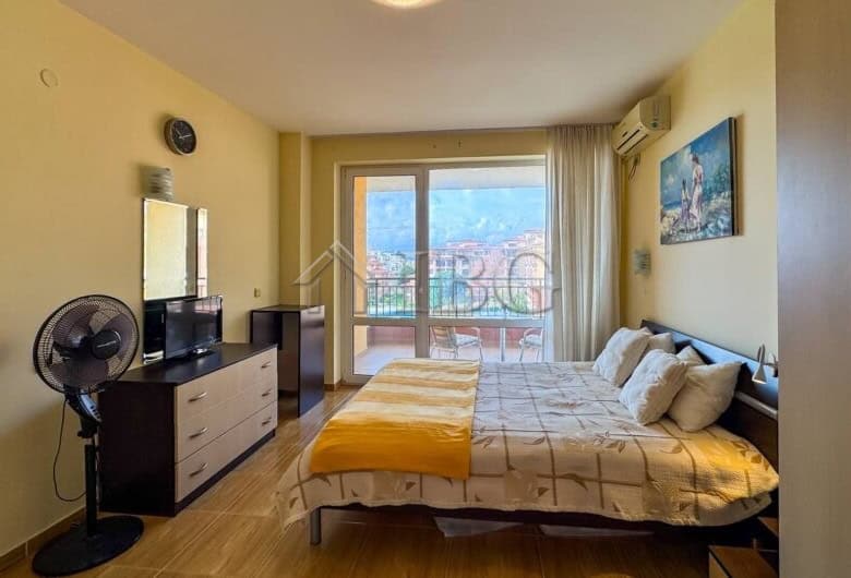 Bright bedroom with balcony view near the beach.