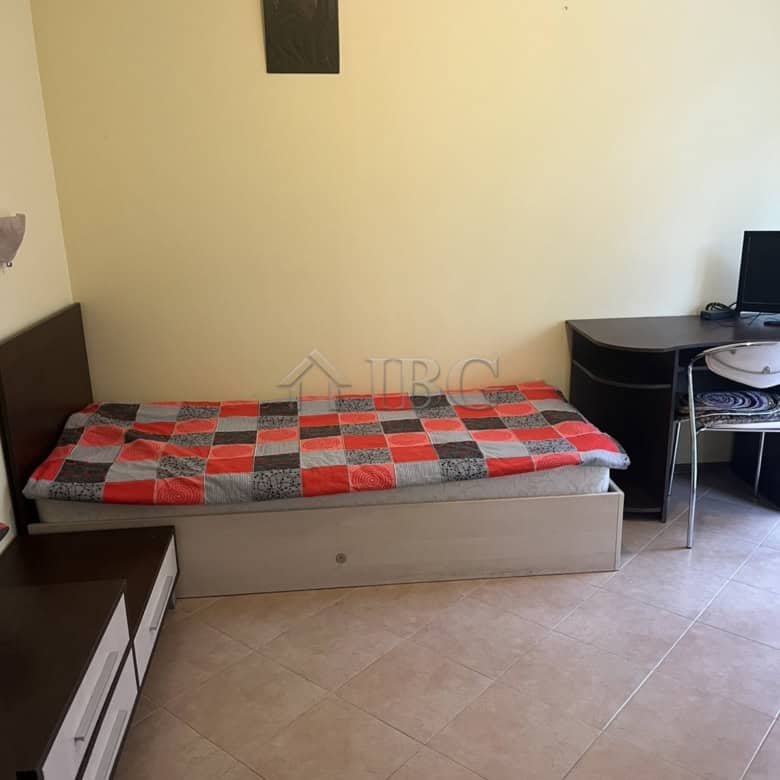 Apartment interior with single bed and workspace in Sunny Beach.