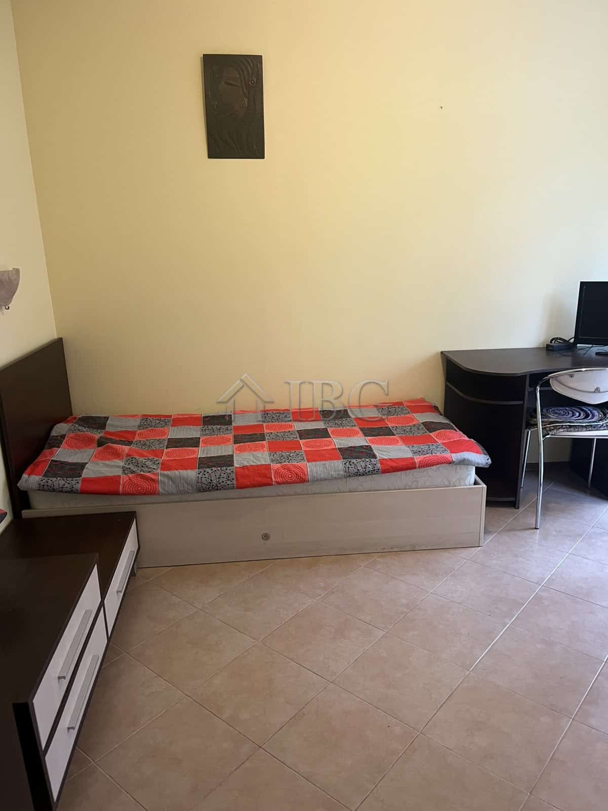Apartment interior with single bed and workspace in Sunny Beach.