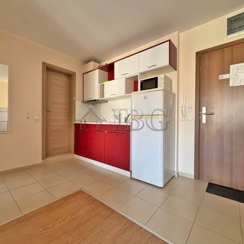 Kitchen with white and red cabinets, microwave, and refrigerator in Sveti Vlas property.