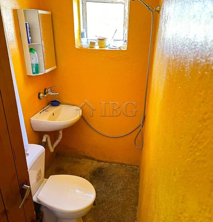 Compact bathroom with toilet and sink in a renovated house.
