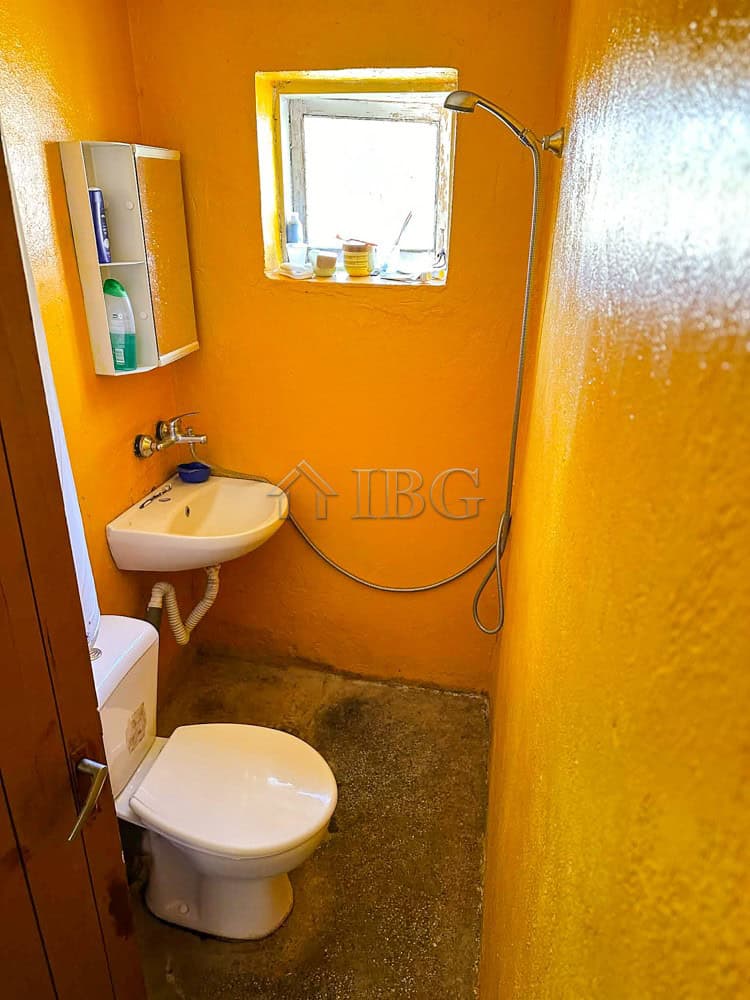 Compact bathroom with toilet and sink in a renovated house.