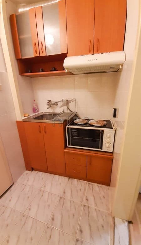 Small kitchen in Drujba 2 apartment with cabinets, microwave, and sink.