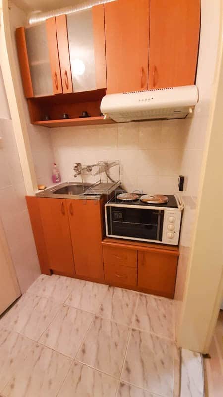 Small kitchen in Drujba 2 apartment with cabinets, microwave, and sink.