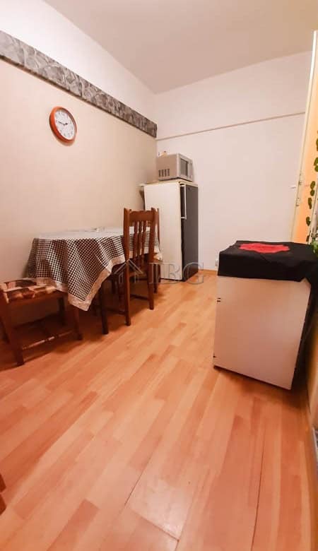 Small apartment interior with dining table, chairs, fridge, microwave, and washing machine in Drujba.