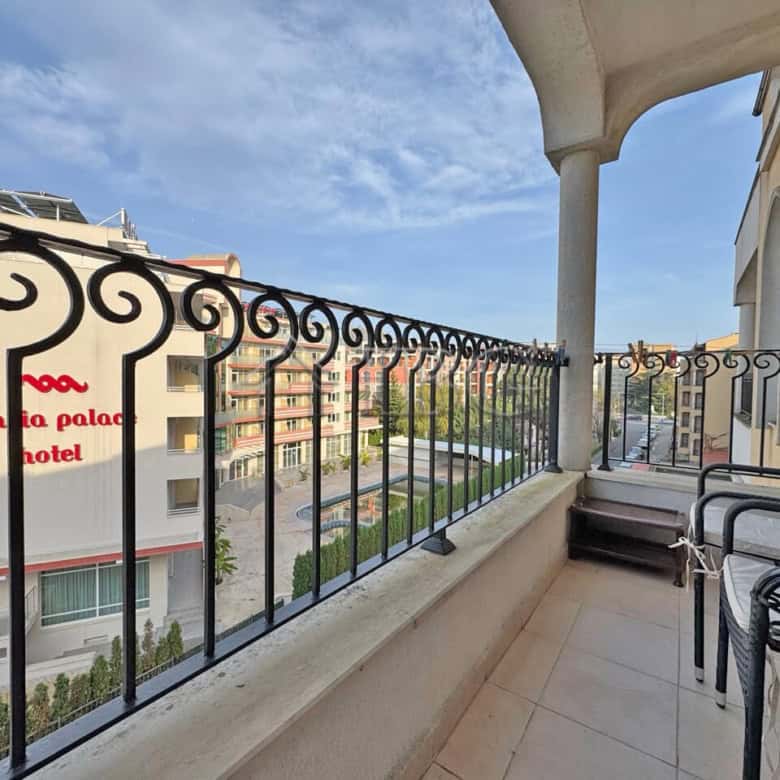 Furnished one-bedroom apartment balcony overlooking Sunny Beach and surrounding buildings.
