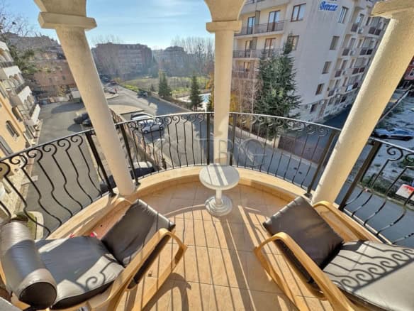 Balcony with seating overlooking Sunny Beach and surrounding buildings.