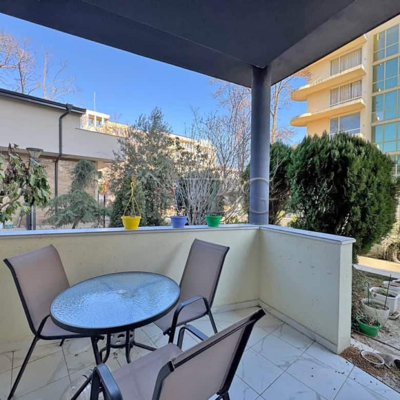 Bright balcony with outdoor seating and garden views, perfect for relaxing or entertaining.