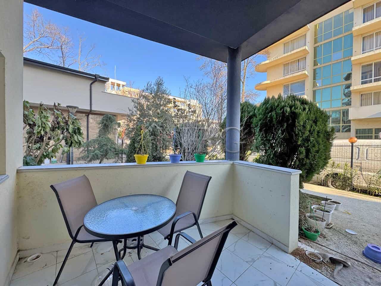 Bright balcony with outdoor seating and garden views, perfect for relaxing or entertaining.