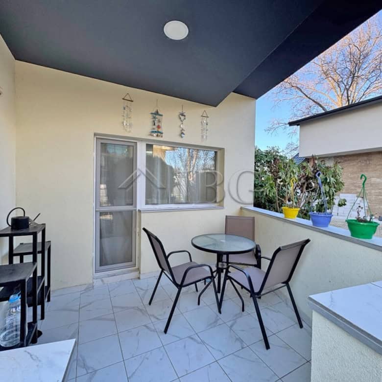 Bright outdoor terrace with seating area and potted plants, perfect for relaxing in the sunny beach.