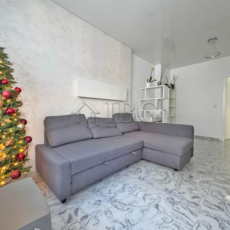 Bright living room with modern decor and large sofa in a sunny apartment.