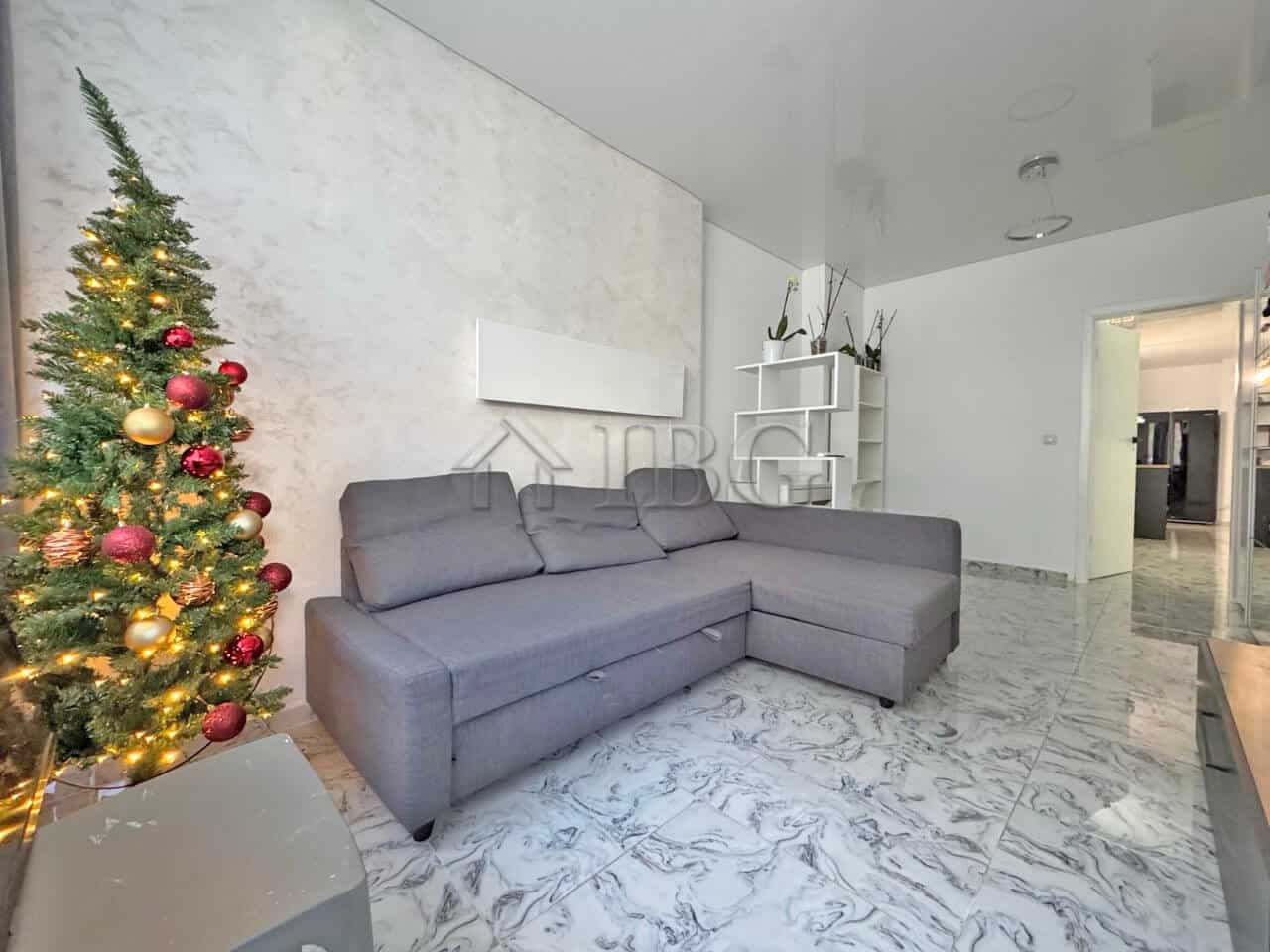 Bright living room with modern decor and large sofa in a sunny apartment.