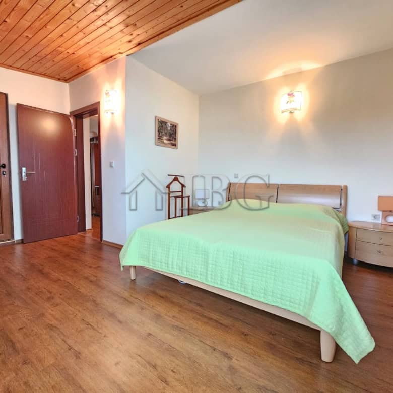 Bright bedroom in Sozopol apartment with sea view, wooden floors, and modern furnishings.