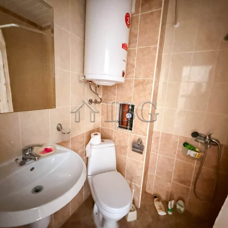 Compact studio bathroom with modern fixtures and water heater.