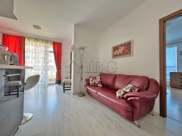 Bright living room with red sofa and large windows with red curtains.