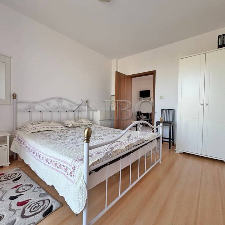 Ground-floor bedroom with white metal bed frame and natural light.