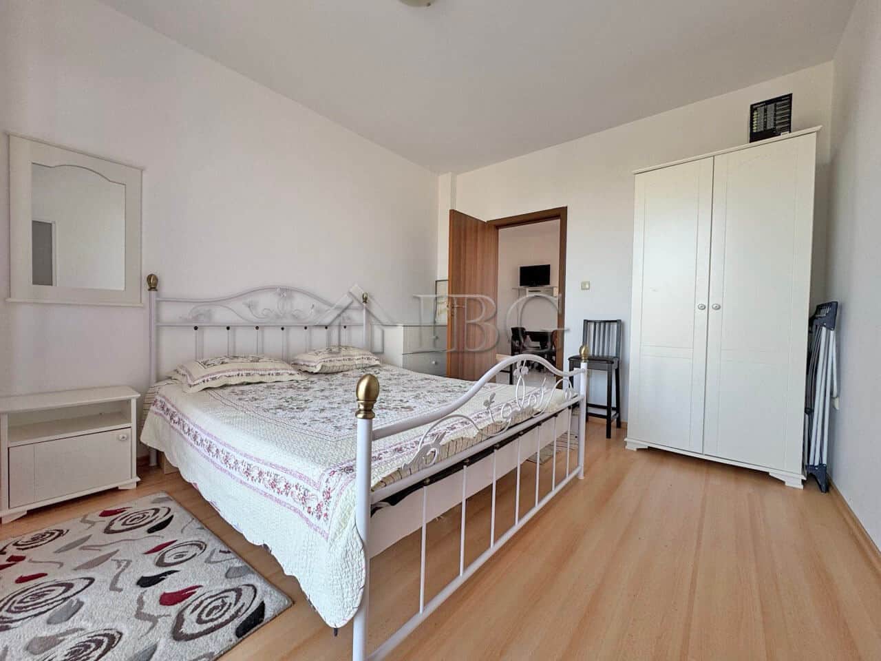 Ground-floor bedroom with white metal bed frame and natural light.