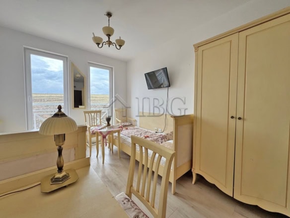 Furnished studio apartment without balcony, bright and airy, overlooking sunny beach and scenic land.