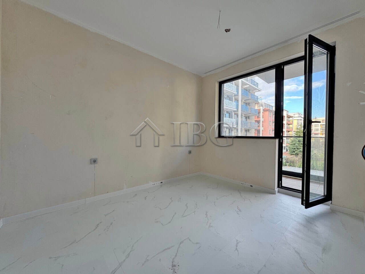 Apartment with spacious living area, large window, and balcony in Sunny Beach.