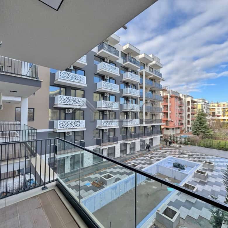 Spacious balcony overlooking pool and city views in a contemporary Sunny Beach residence.