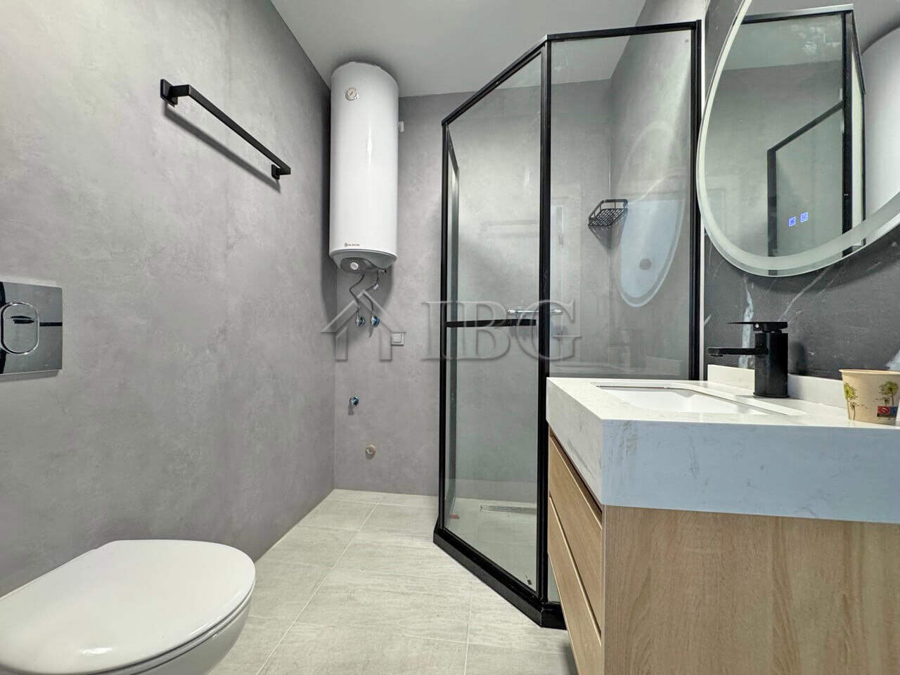 Bright bathroom featuring a glass shower enclosure, toilet, and stylish vanity with mirror.