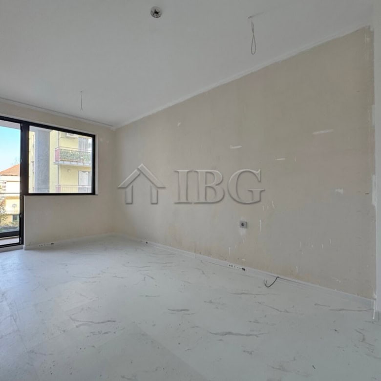 Bright empty apartment with large window and balcony access.