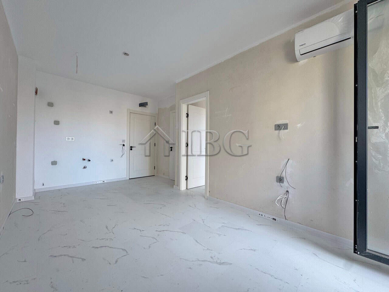 Bright, unfurnished one-bedroom apartment in Sunny Beach with large windows and air conditioning.
