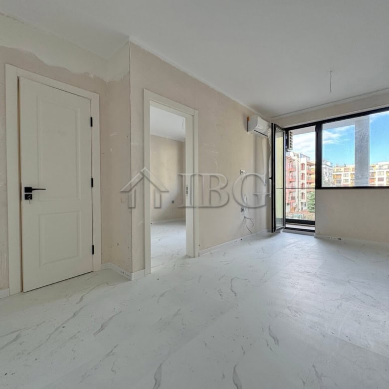 Spacious living room with natural light and balcony access.