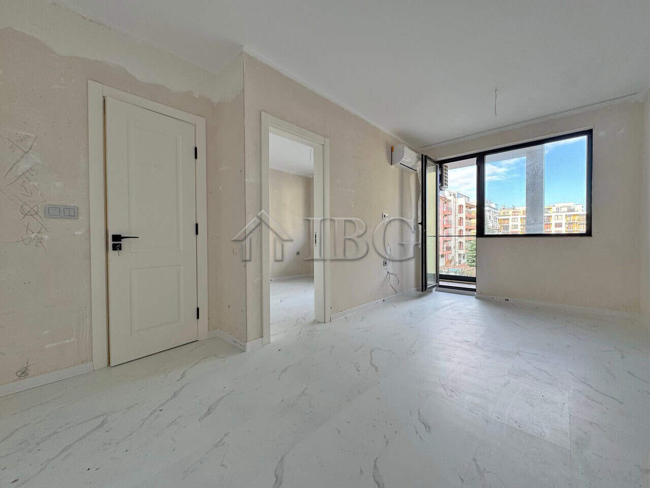 Spacious living room with natural light and balcony access.