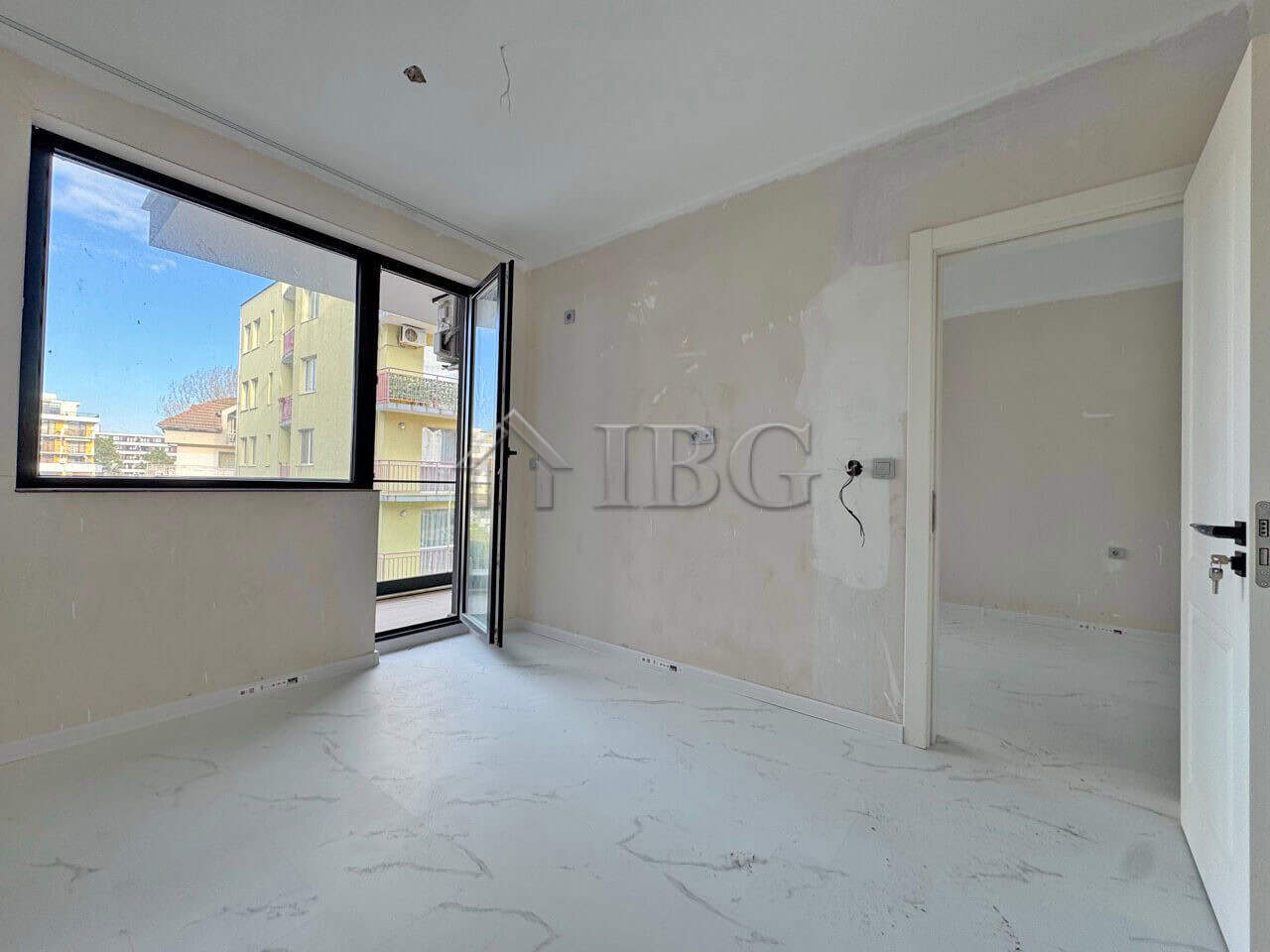 Bright, unfurnished one-bedroom apartment with large windows in Sunny Beach, Bulgaria.