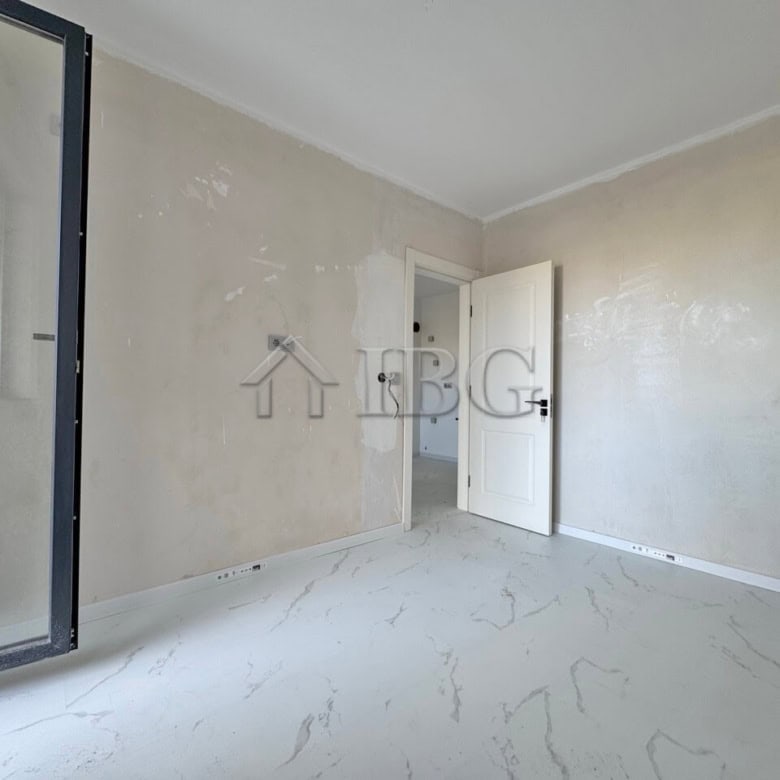 Bright empty one-bedroom apartment with large window and open door.