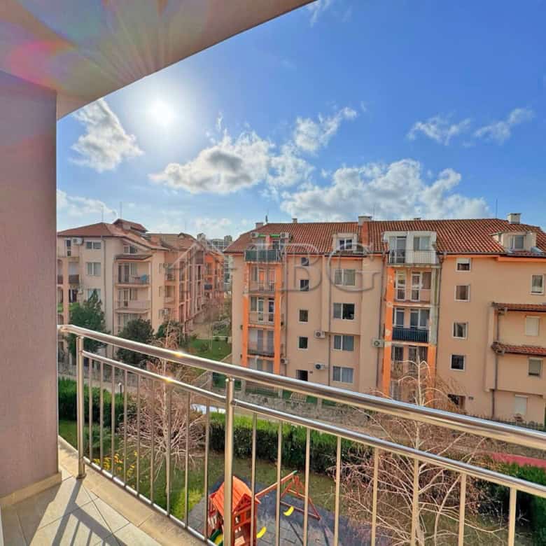 Balcony view of Sunny Beach apartments with pool and blue sky.