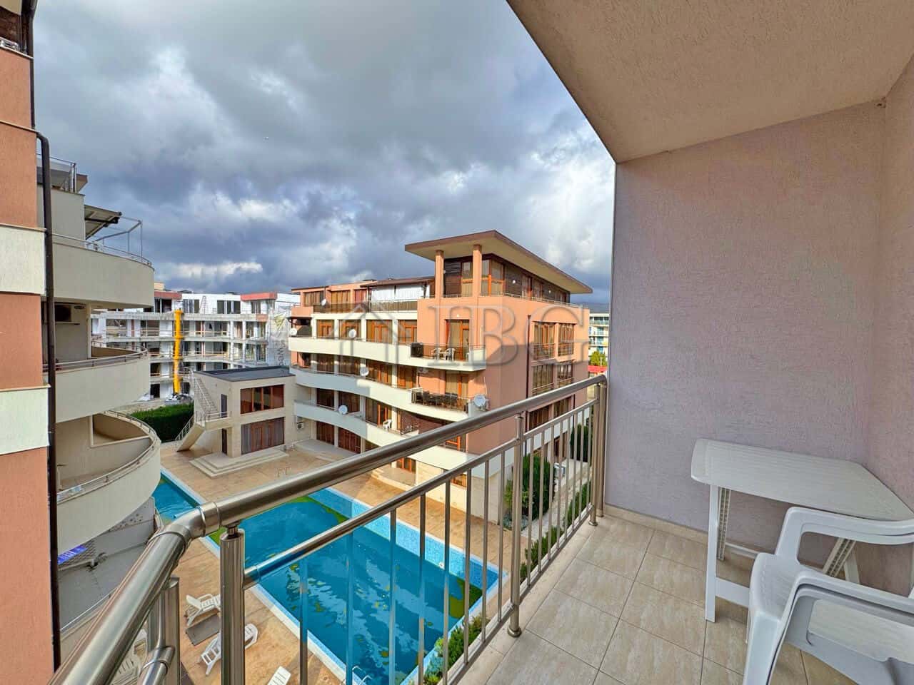 Comfortable apartment overlooking the pool with balcony and seating area.