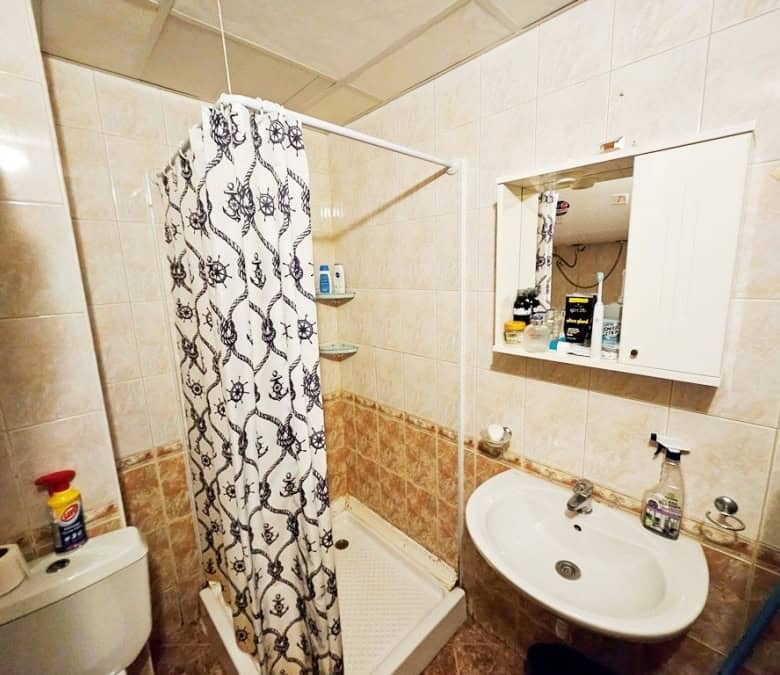 Bright bathroom with shower, sink, and mirror in Prestige City apartment.