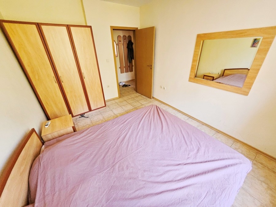 Comfortable bedroom with wardrobe and large wall mirror in a modern apartment.