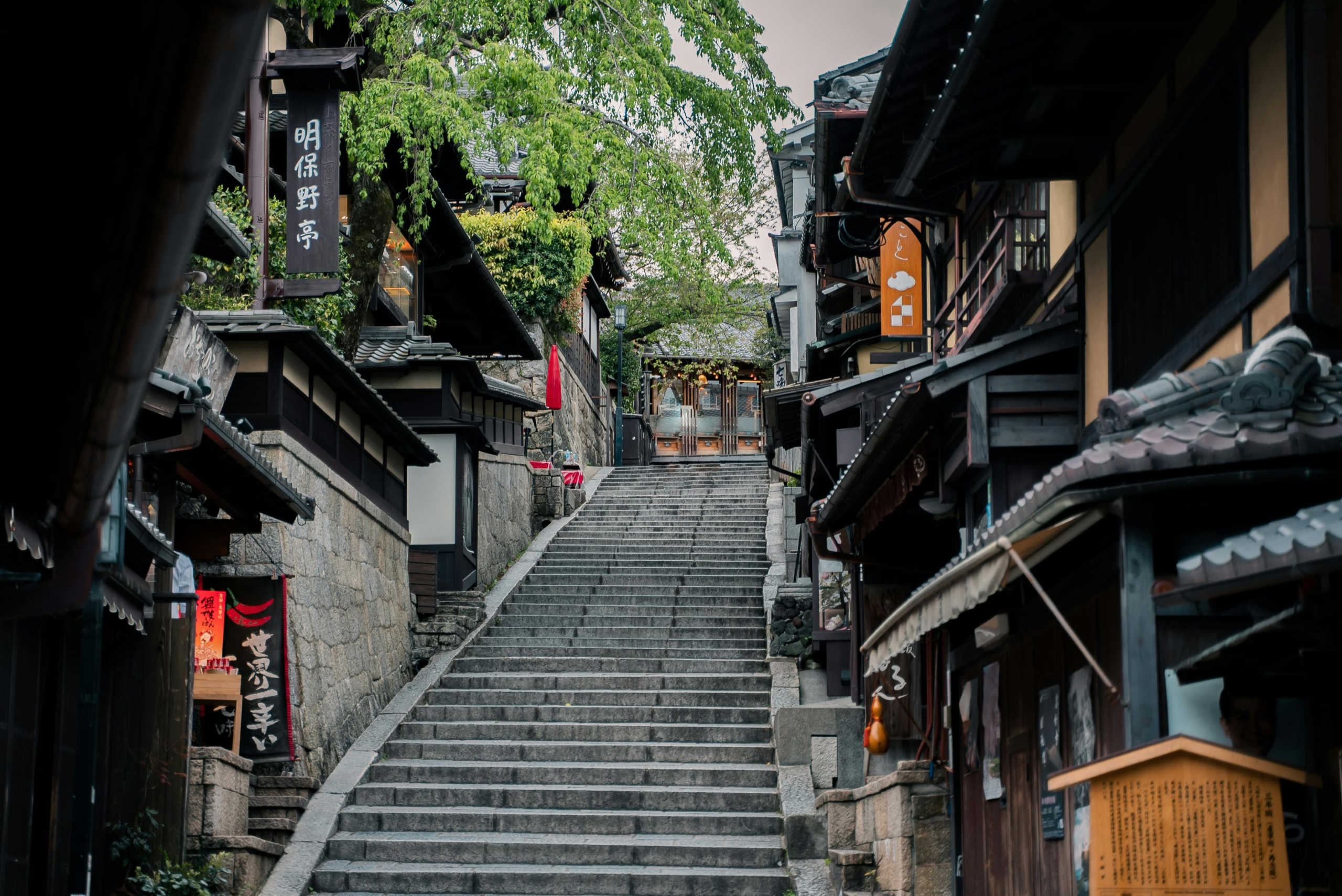historic street in Kyoto featuring traditional wooden buildings and a stone staircase