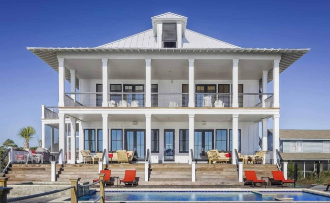 Elegant white beach house with large balconies and pool, perfect for seaside living.